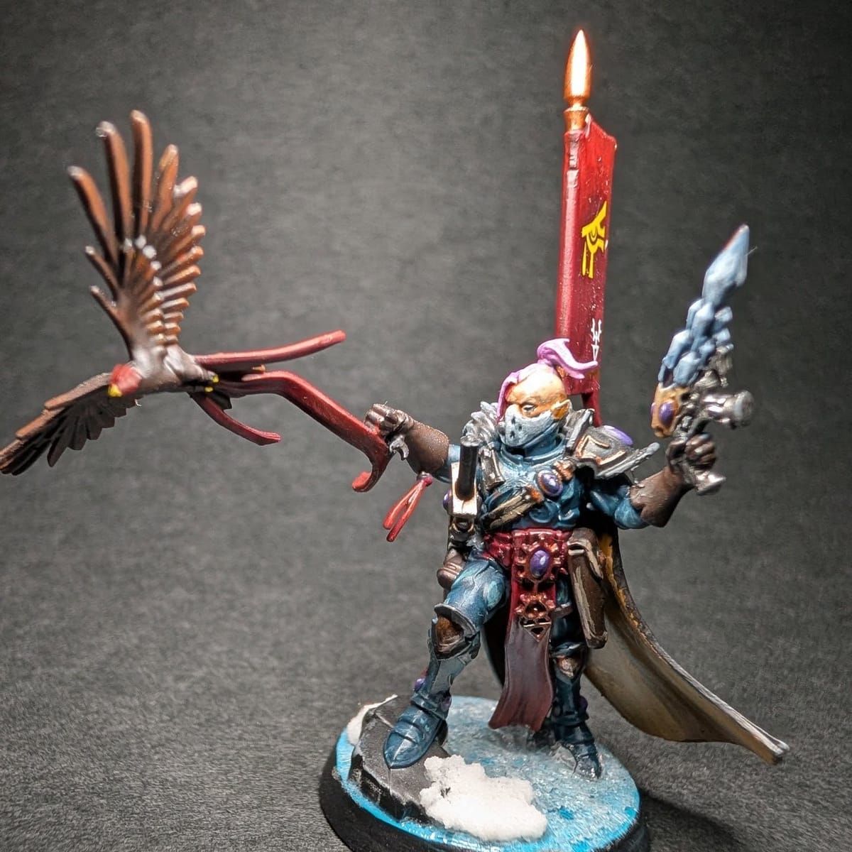 Aeldari character miniature with a lit candle and red robes