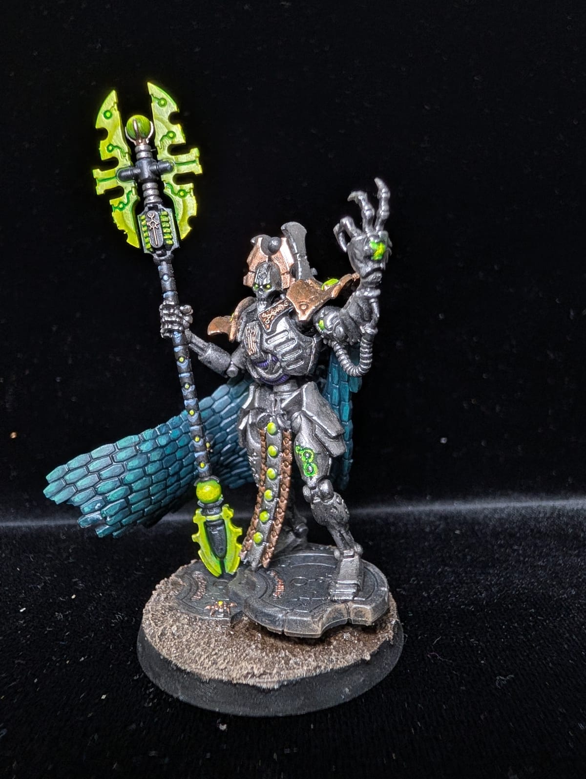 Necron Imotekh the Stormlord in silver with a teal cloak and a glowing green staff
