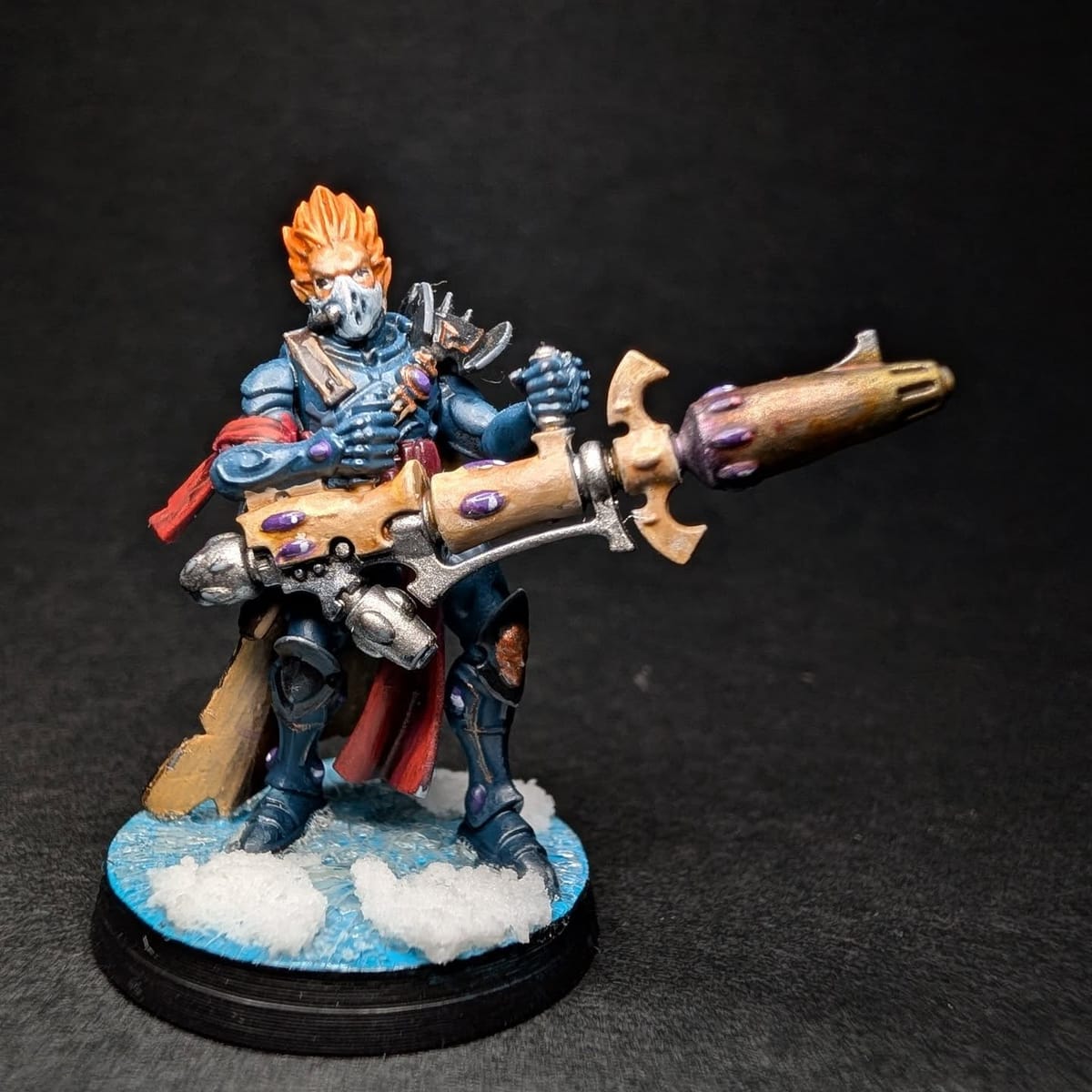 Character miniature with orange hair and a long rifle on a snow base