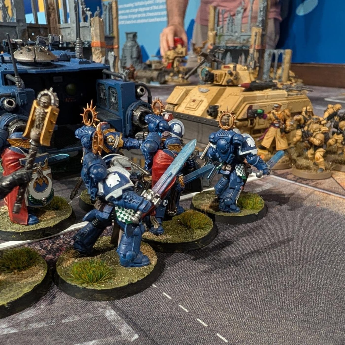 Ultramarines advancing through painted ruined city terrain on a gaming table