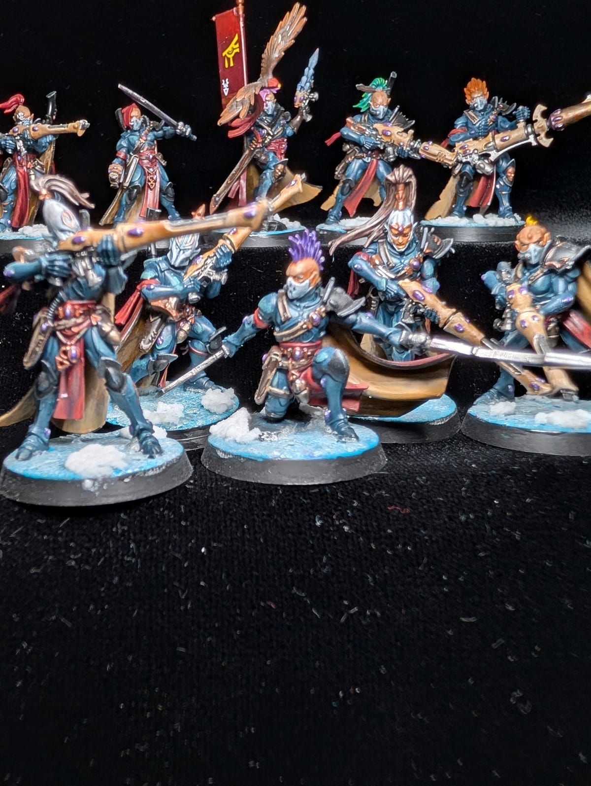 Squad of ten Aeldari Corsair Voidreavers in teal and red with white hair and banners, on snow bases